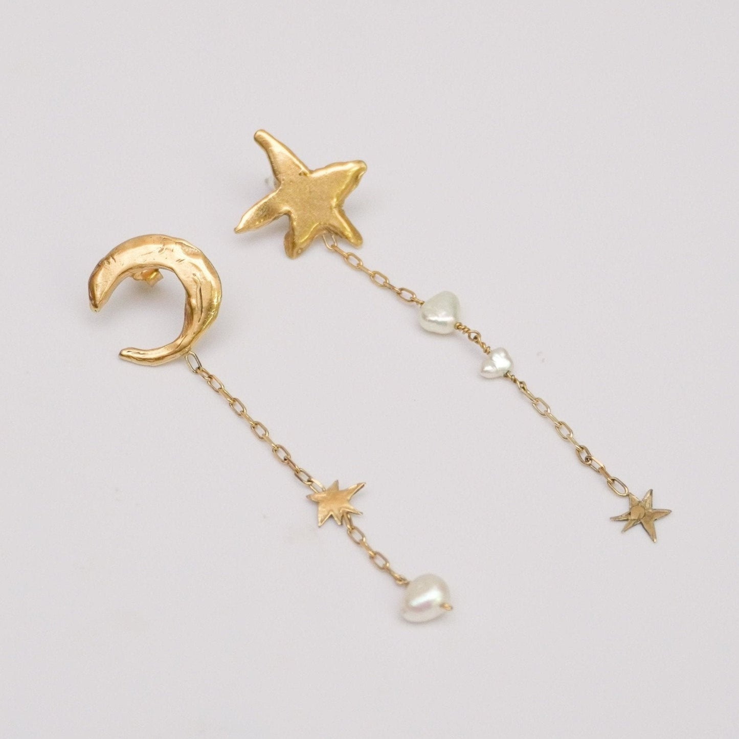 Asymmetric drop stud earrings with organic moon and star shapes and natural pearls, gold-plated