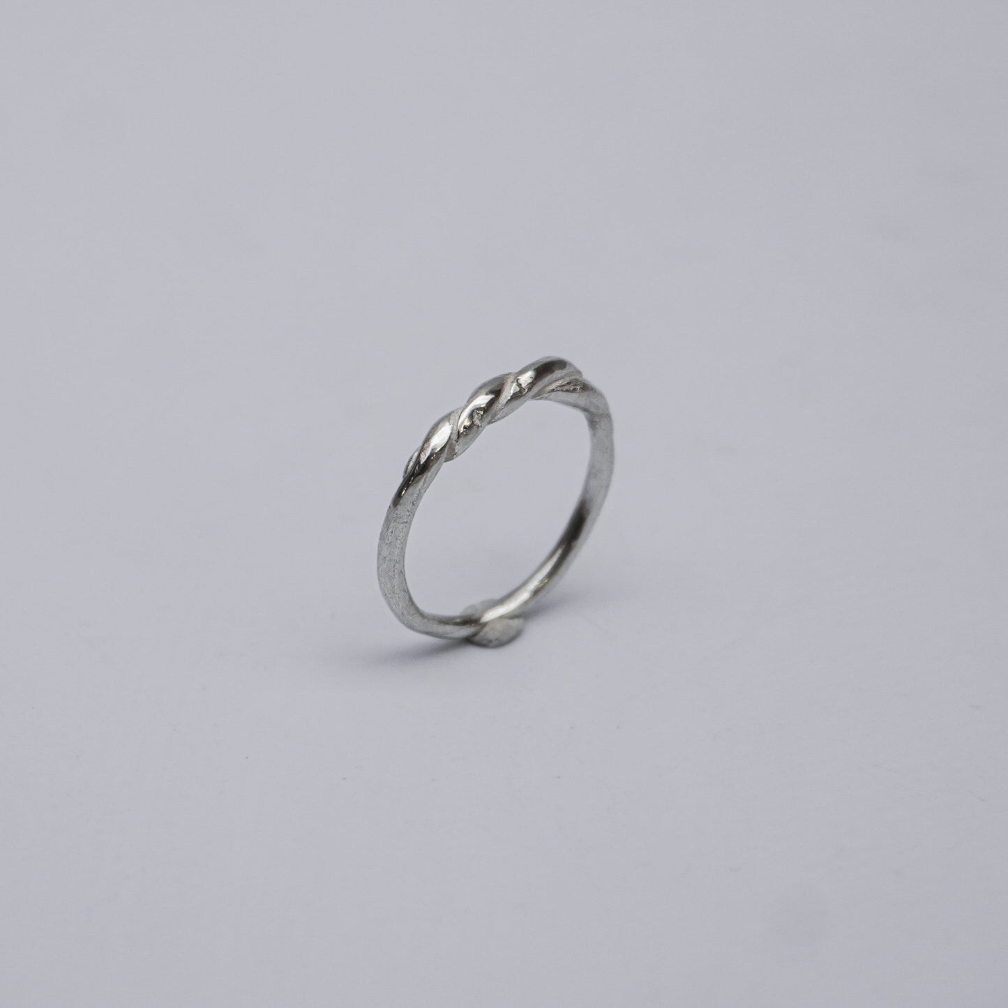 Handmade and unique sterling silver ring featuring a subtle, elegant twist design. Crafted using the traditional lost-wax casting technique, this artisanal piece reflects organic minimalism and slow design values. Made in a small studio in Porto, Portugal, the ring embodies natural imperfection and delicate craftsmanship in 925 silver.