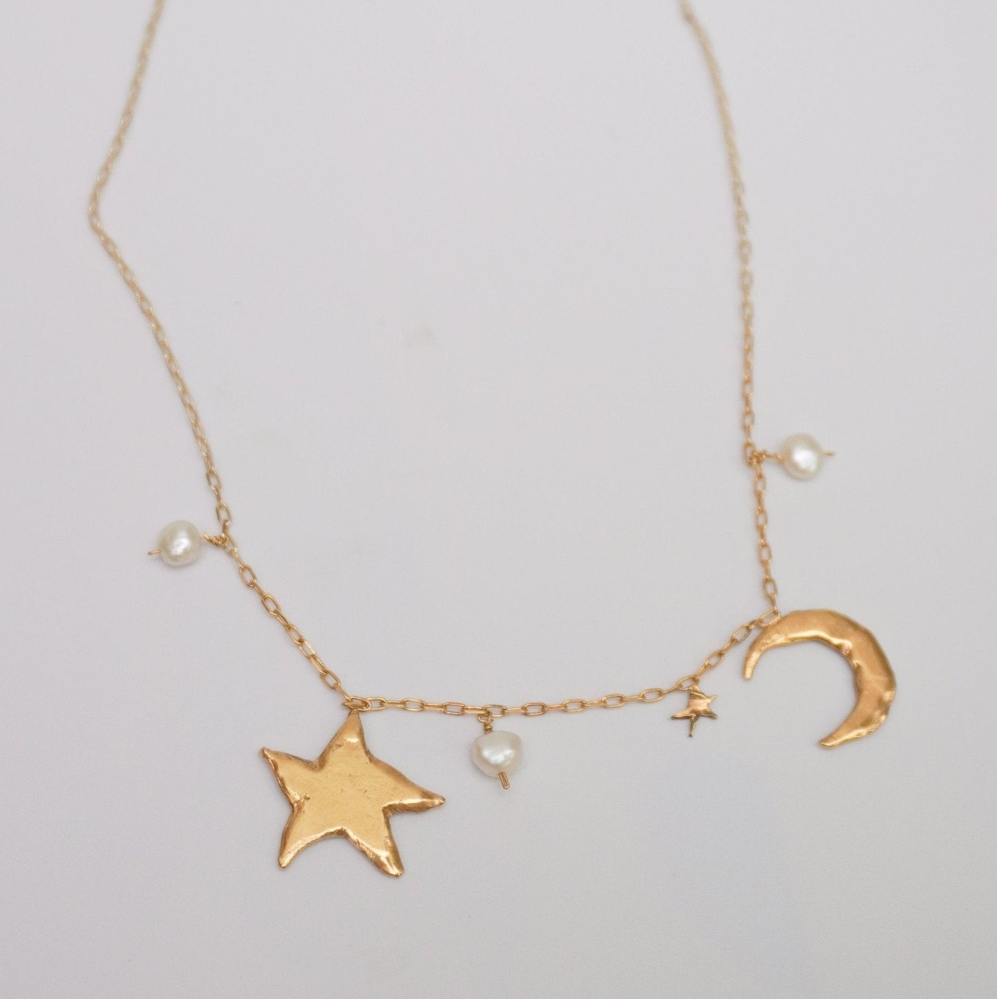 Necklace with organic shaped moon, star and natural pearl pendants, gold-plated