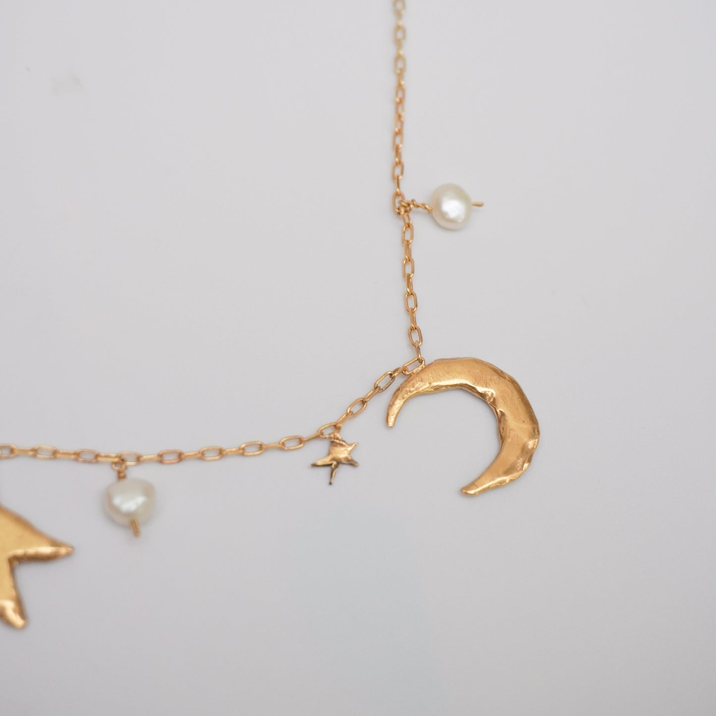Necklace with organic shaped moon, star and natural pearl pendants, gold-plated