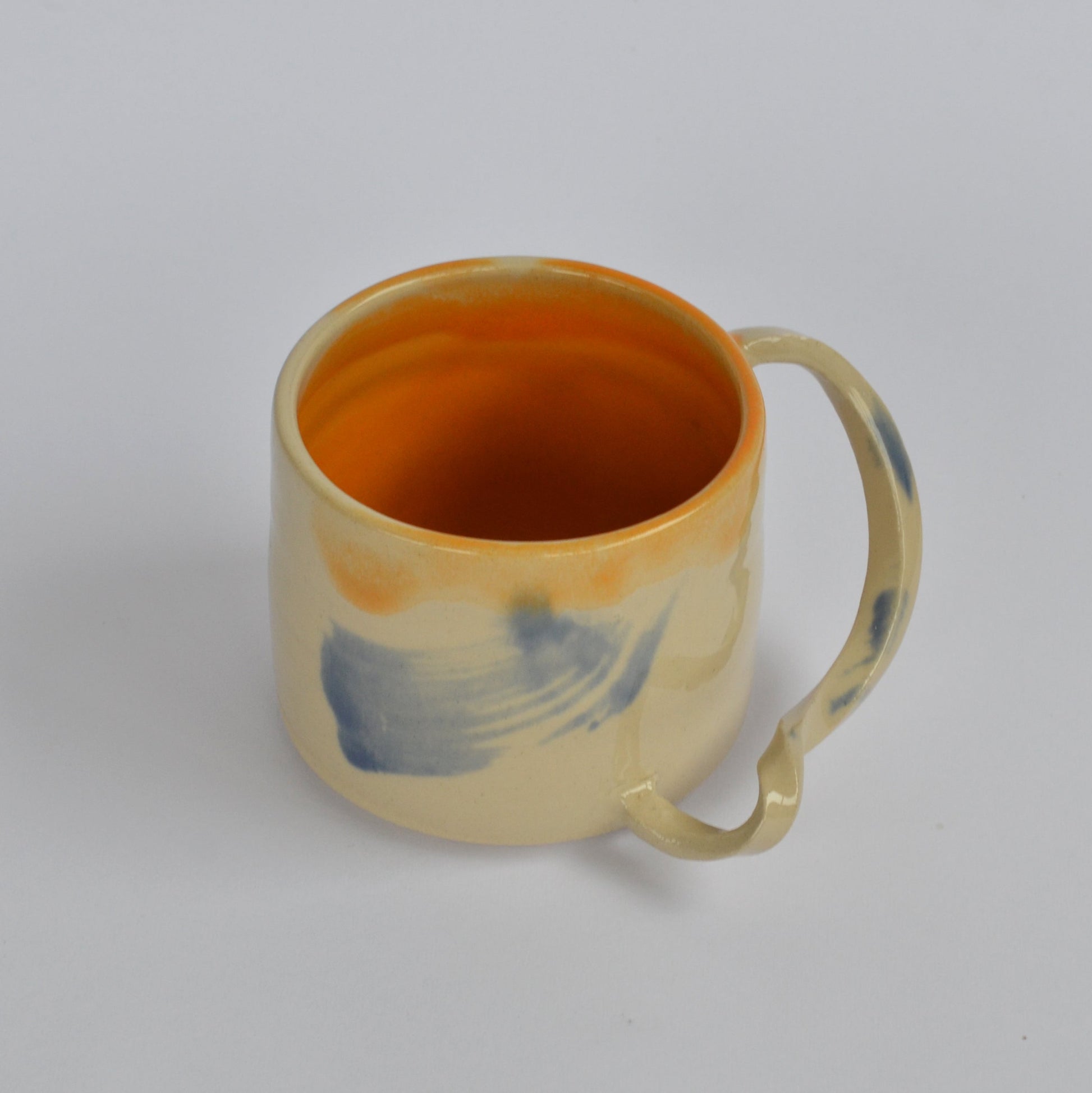 GIVE IT A TWIST handmade ceramics mug orange interior and blue brushes