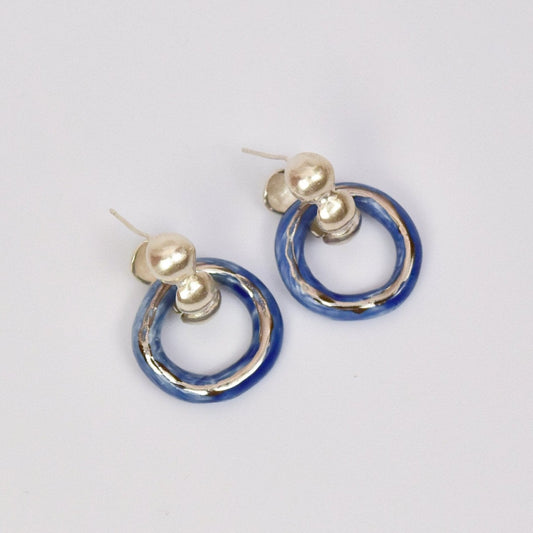 Artisanal handmade porcelain hoop earrings with glossy blue and gold or silver enamel finish. Unique ceramic design with gold stud posts, perfect for modern, minimalist, and statement jewelry lovers. Lightweight artisanal hoops for everyday wear or special occasions.