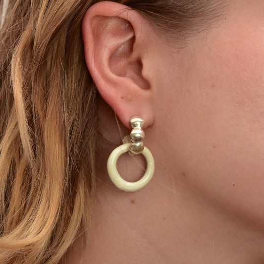Artisanal handmade porcelain hoop earrings with glossy white and gold enamel finish. Unique ceramic design with gold stud posts, perfect for modern, minimalist, and statement jewelry lovers. Lightweight artisanal hoops for everyday wear or special occasions