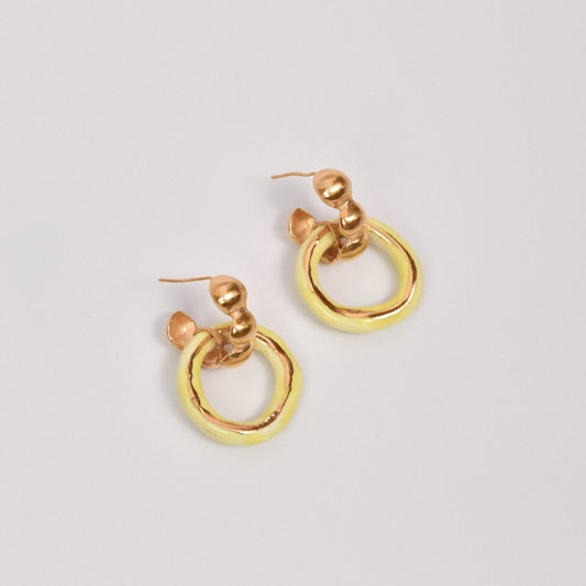 Artisanal handmade porcelain hoop earrings with glossy yellow and gold enamel finish. Unique ceramic design with gold stud posts, perfect for modern, minimalist, and statement jewelry lovers. Lightweight artisanal hoops for everyday wear or special occasions