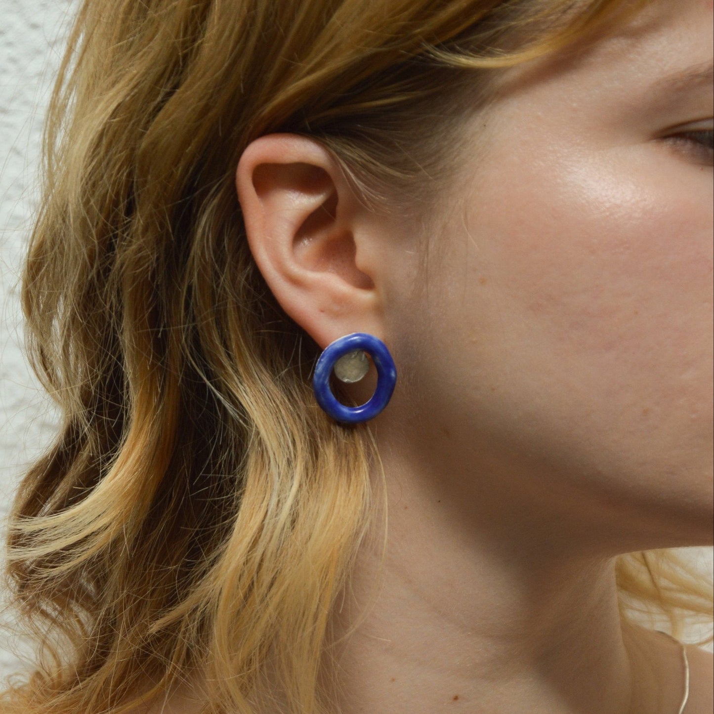 Artisanal handmade blue porcelain stud earrings with unique oval hoop design and hammered gold or silver detail. Lightweight and modern ceramic earrings, perfect for minimalist or statement jewelry styles. Ideal for everyday wear or as a thoughtful handmade gift.