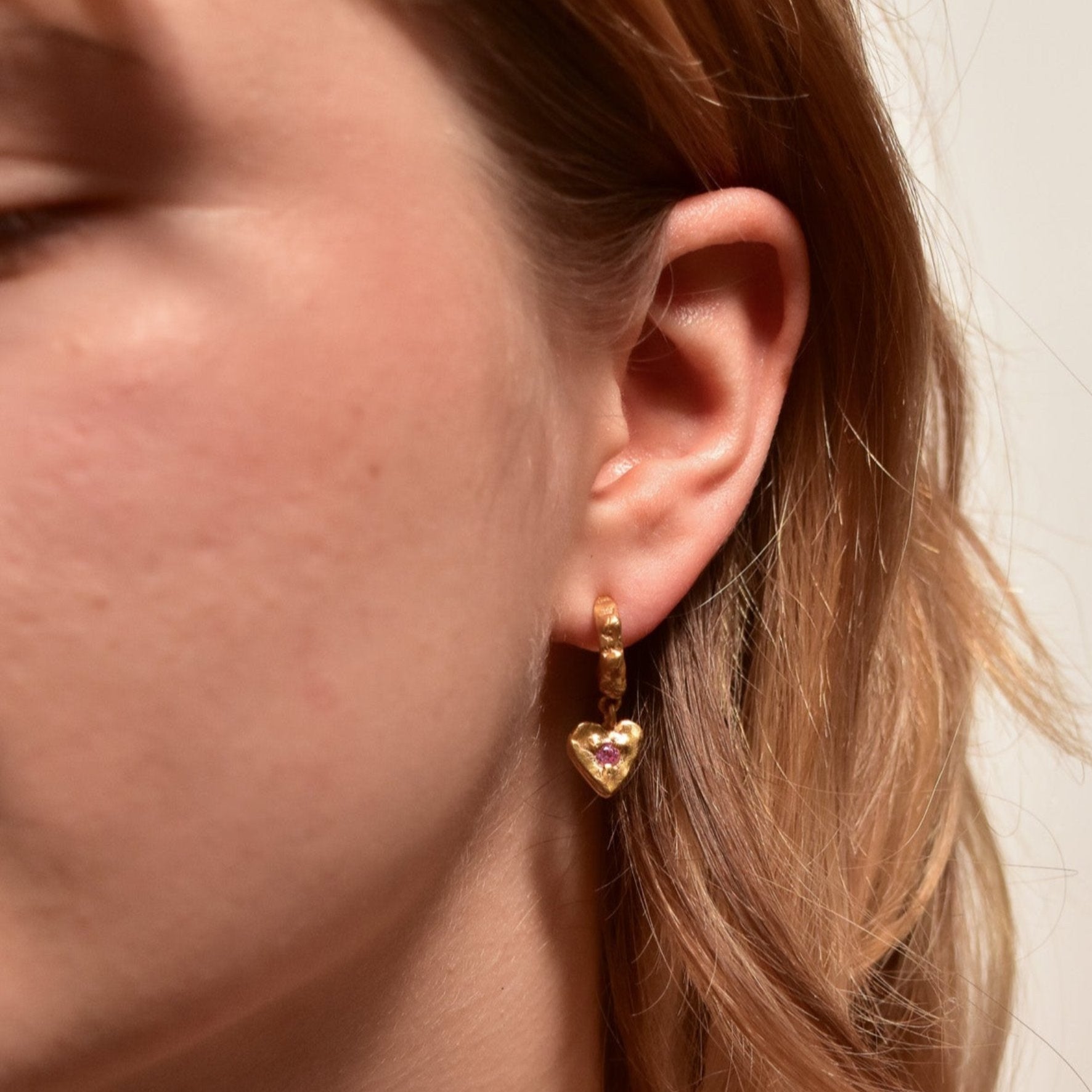 organic gold hoop earring heart pendant stone