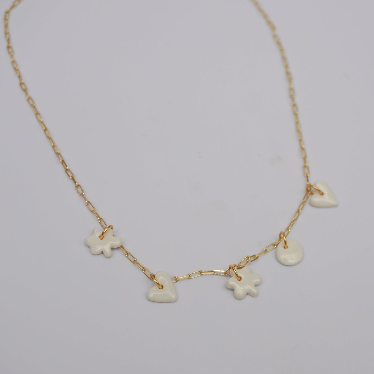 Gold plated chain with handmade white porcelain pendants.