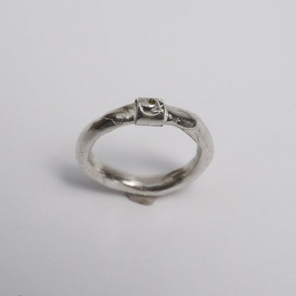Artisanal handmade silver ring with sculptural organic band, featuring a central green zirconia stone. Unique one-of-a-kind design crafted in solid 925 sterling silver using the traditional lost-wax technique. Elegant, raw, slightly irregular surface with a minimal yet expressive form, created by a contemporary jewelry artist in Porto.