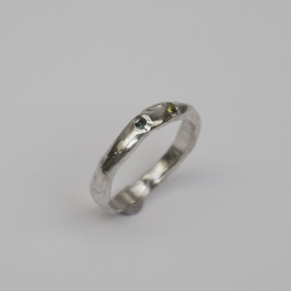 Artisanal handmade silver ring with organic, slim band and two embedded synthetic stones in green and blue tones. Unique one-of-a-kind jewelry piece crafted from solid 925 sterling silver using lost-wax casting. Sculptural, slightly irregular finish with minimal, contemporary design. Created in a small studio in Porto.

