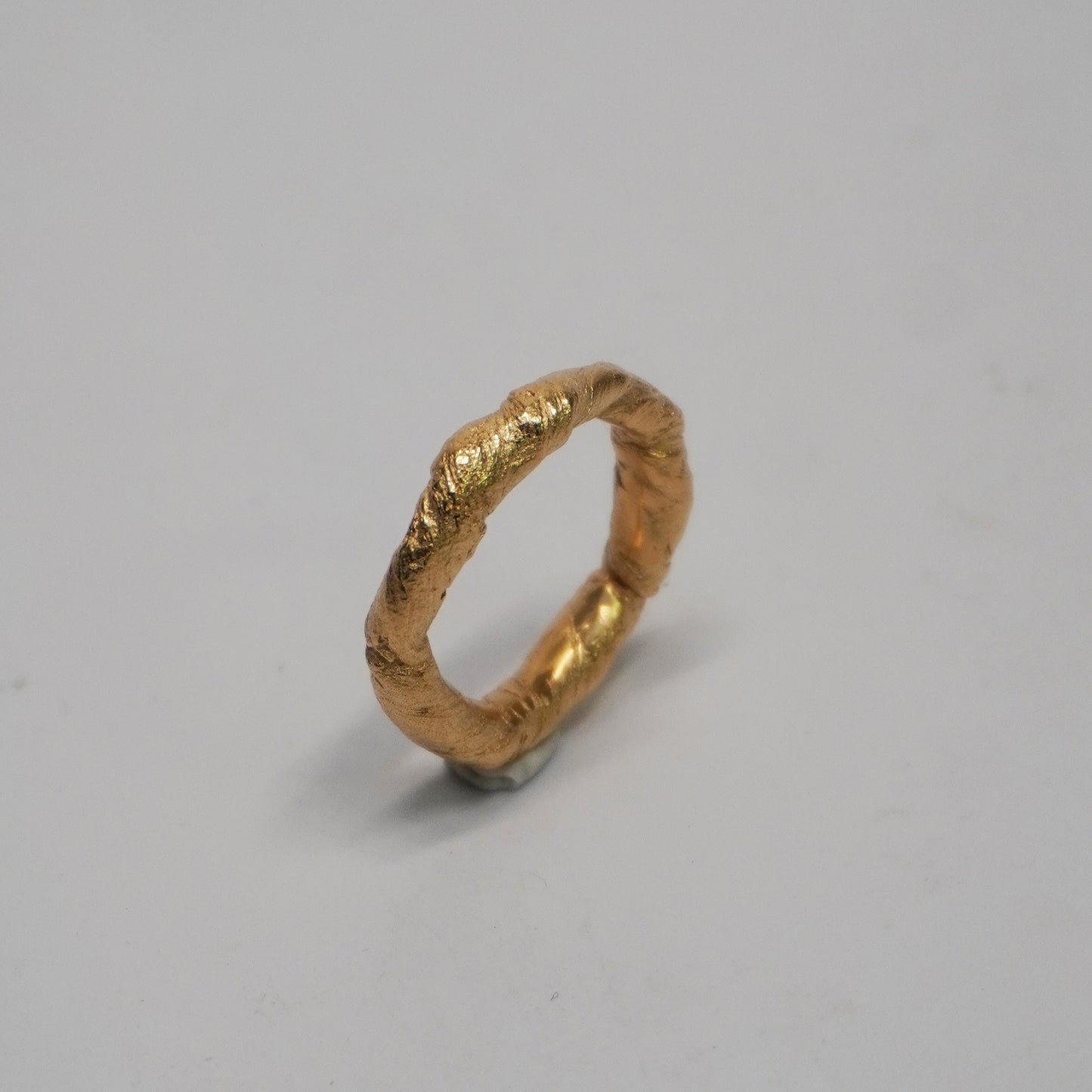 Handmade 24k gold-plated brass ring with a textured, slightly irregular surface. Cast using the lost-wax technique in a Porto-based studio. Unique, artisanal band with a minimal, handcrafted look.


