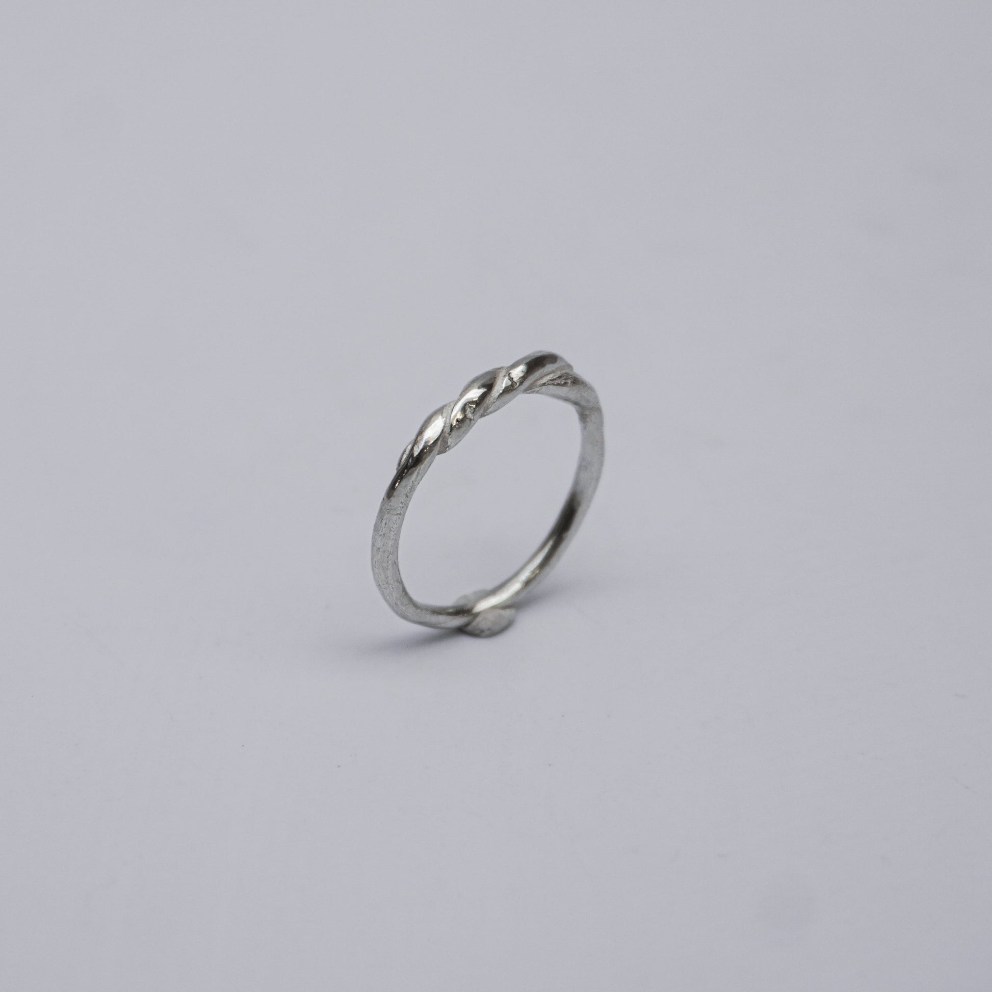 Handmade and unique sterling silver ring featuring a subtle, elegant twist design. Crafted using the traditional lost-wax casting technique, this artisanal piece reflects organic minimalism and slow design values. Made in a small studio in Porto, Portugal, the ring embodies natural imperfection and delicate craftsmanship in 925 silver.

