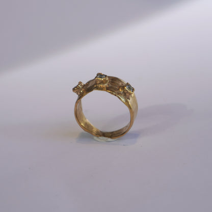 Handcrafted gold ring with organic sculpted band and three set gemstones