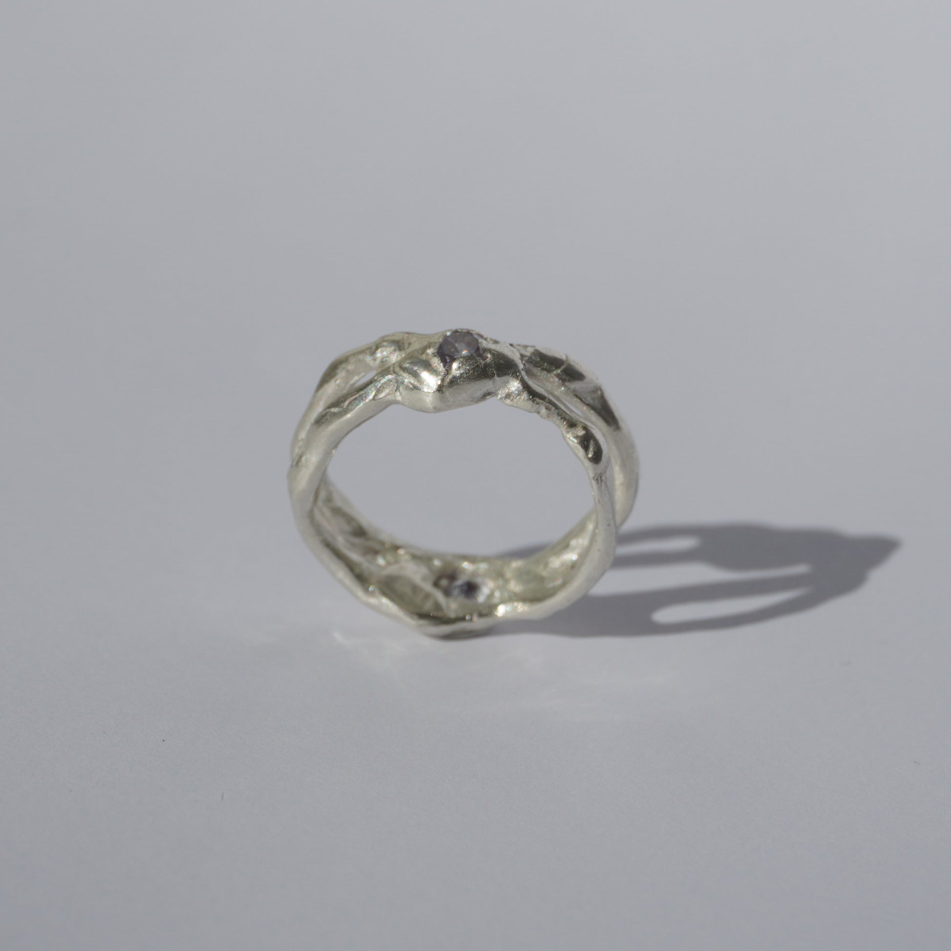 Handcrafted openwork silver ring with organic shapes and a small gemstone accent