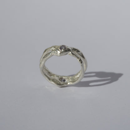 Handcrafted openwork silver ring with organic shapes and a small gemstone accent