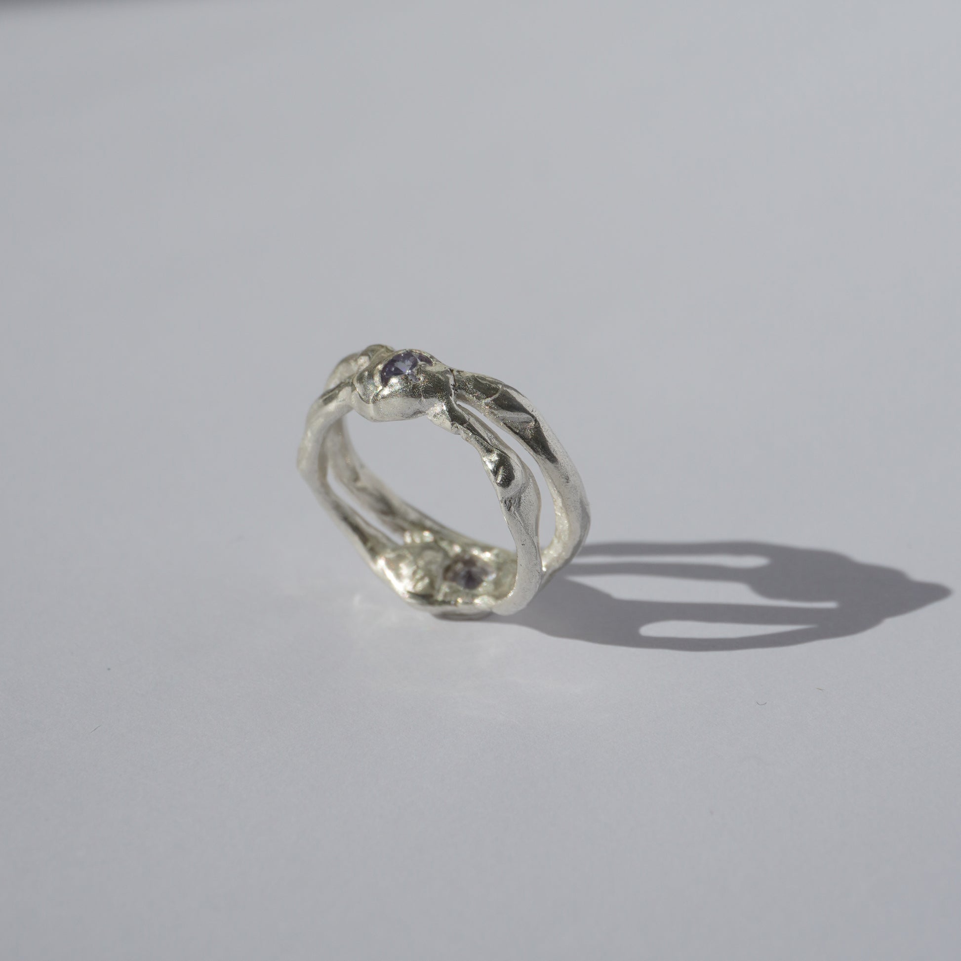 Handcrafted openwork silver ring with organic shapes and a small gemstone accent