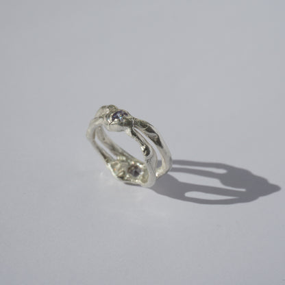Handcrafted openwork silver ring with organic shapes and a small gemstone accent