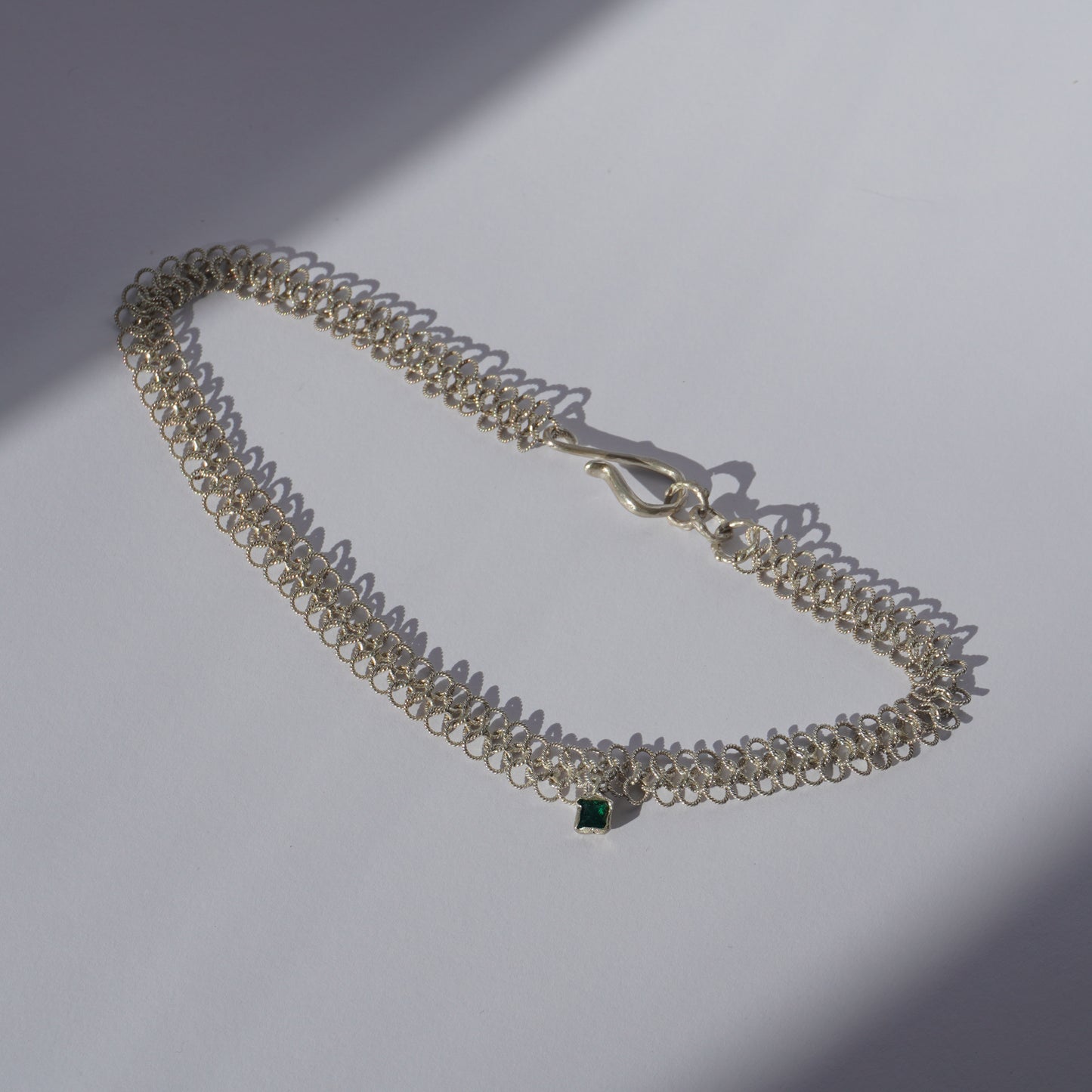 Gold-plated handcrafted double-chain choker with lace-like texture and a small green hand-set gemstone