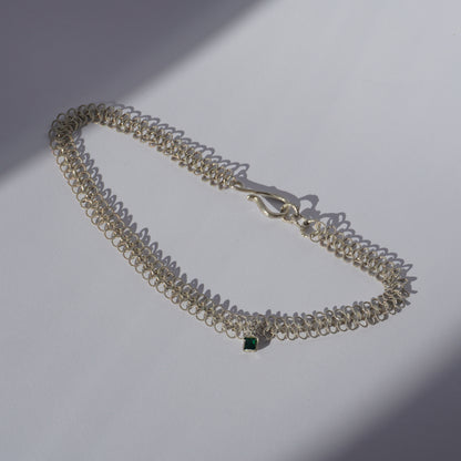 Gold-plated handcrafted double-chain choker with lace-like texture and a small green hand-set gemstone