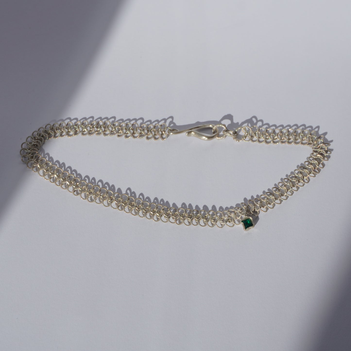 Silver handcrafted double-chain choker with lace-like texture and a small green hand-set gemstone