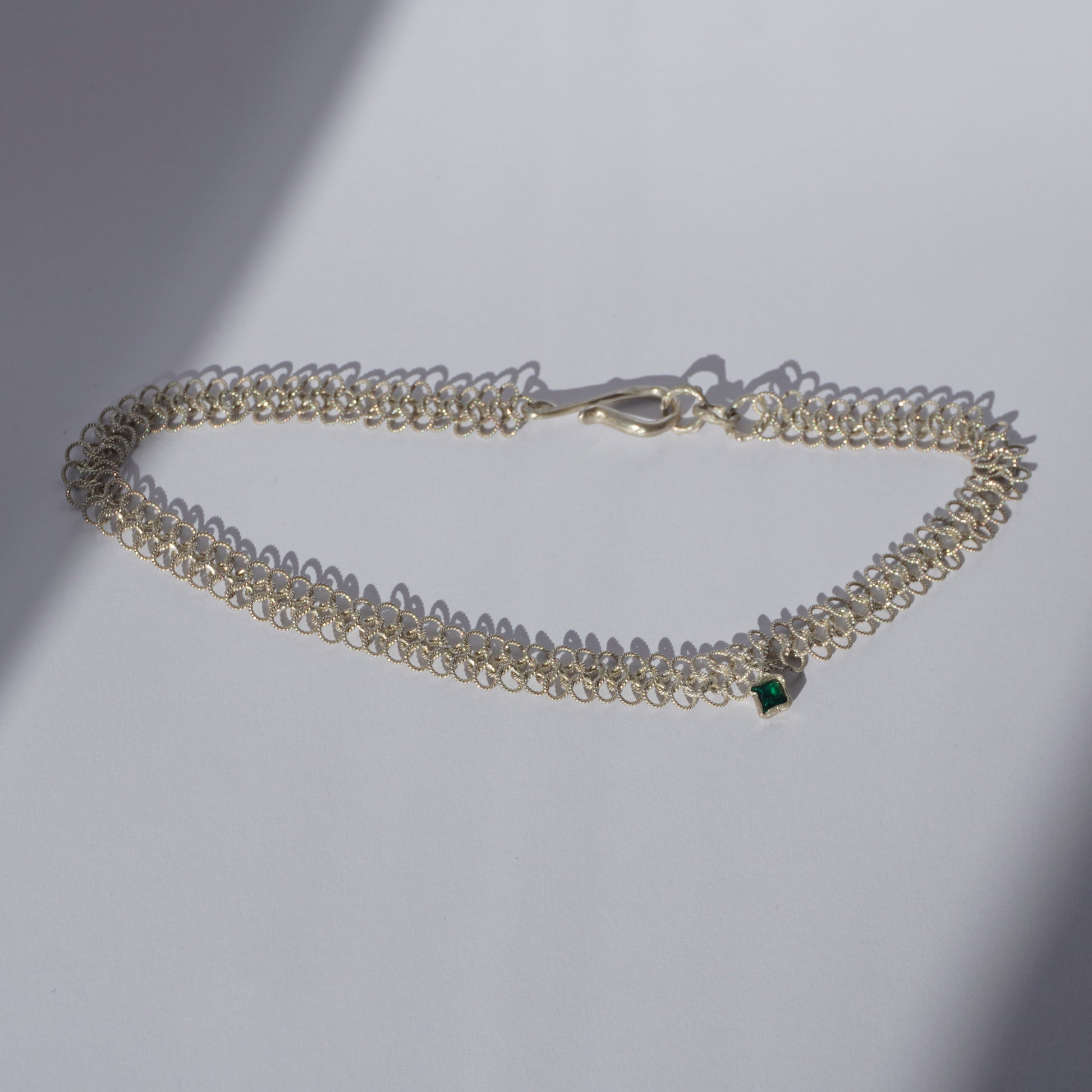 Silver handcrafted double-chain choker with lace-like texture and a small green hand-set gemstone