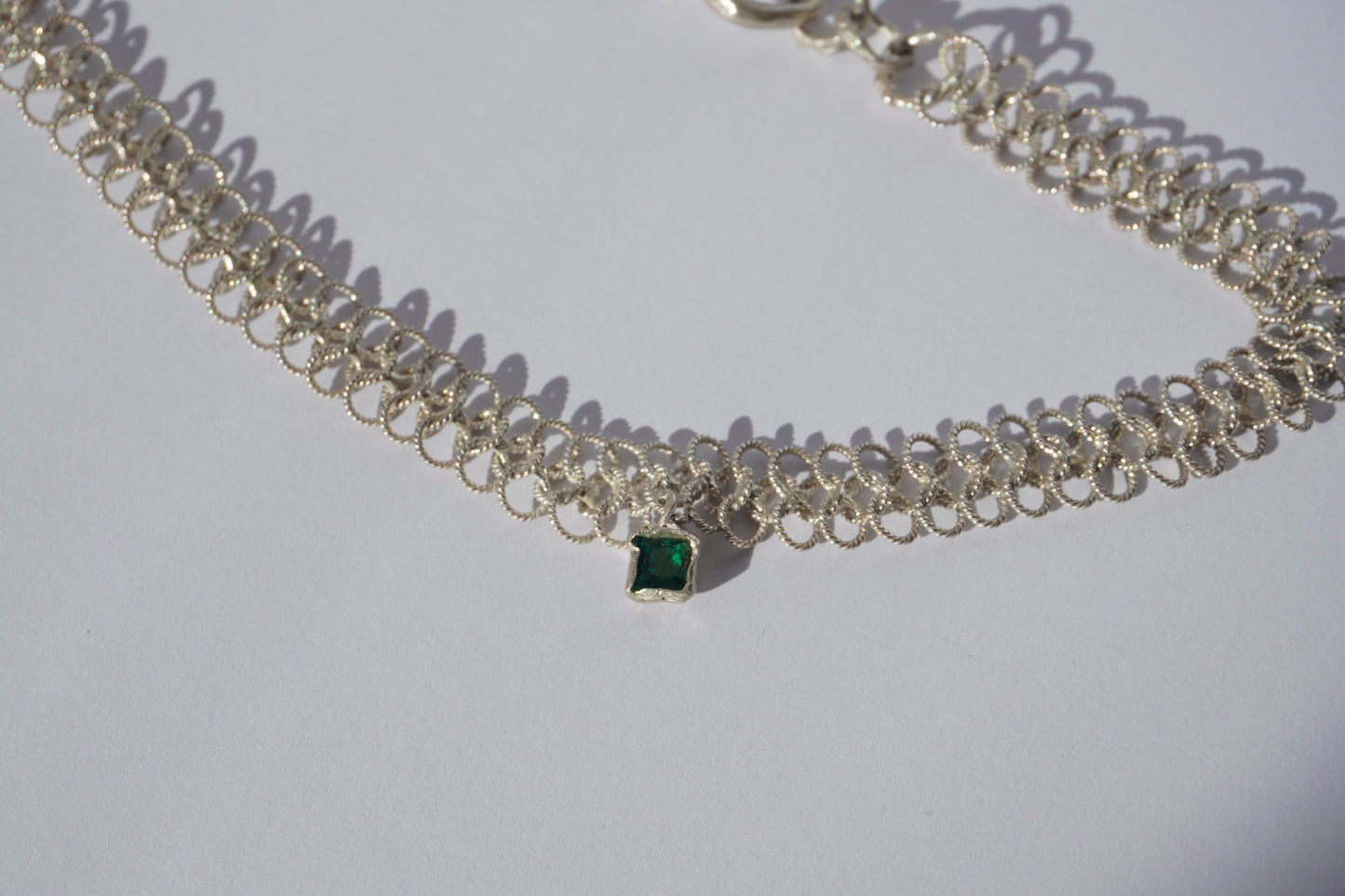 Silver handcrafted double-chain choker with lace-like texture and a small green hand-set gemstone