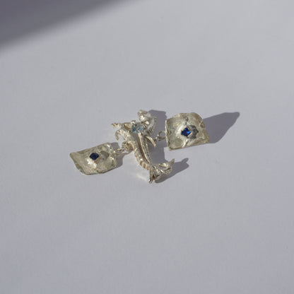 Handcrafted sterling silver earrings with organic sculptural forms and blue hand-set gemstones