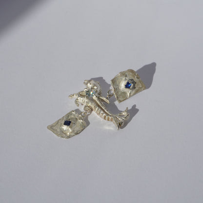 Handcrafted sterling silver earrings with organic sculptural forms and blue hand-set gemstones