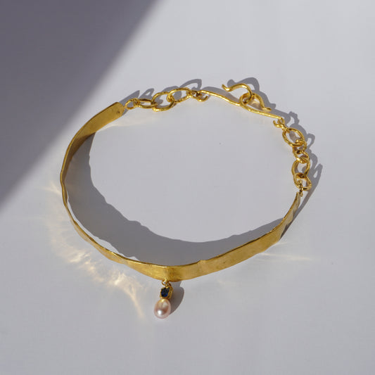 Gold-plated handcrafted choker with sculptural band, hand-set gemstone, and freshwater pearl pendant