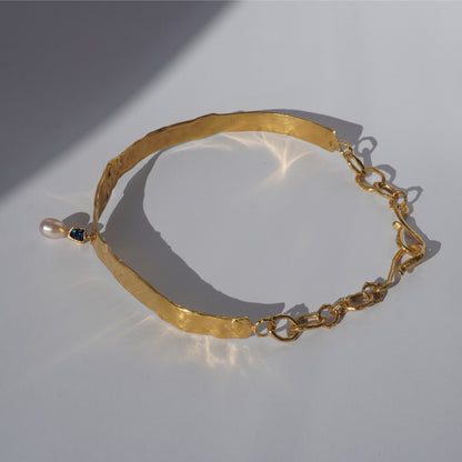 Gold-plated handcrafted choker with sculptural band, hand-set gemstone, and freshwater pearl pendant