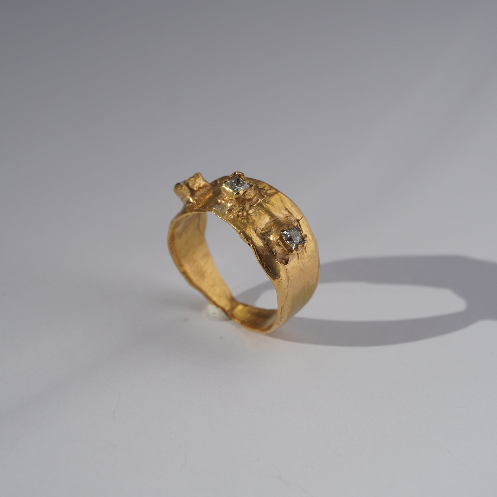 Handcrafted gold ring with organic sculpted band and three set gemstones