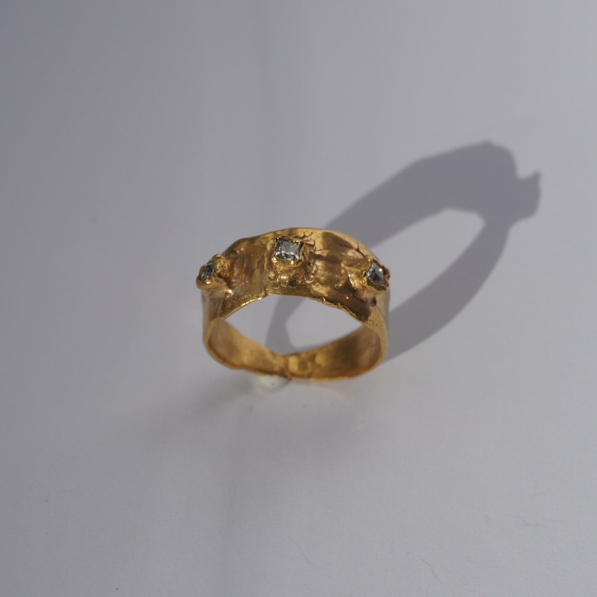 Handcrafted gold ring with organic sculpted band and three set gemstones