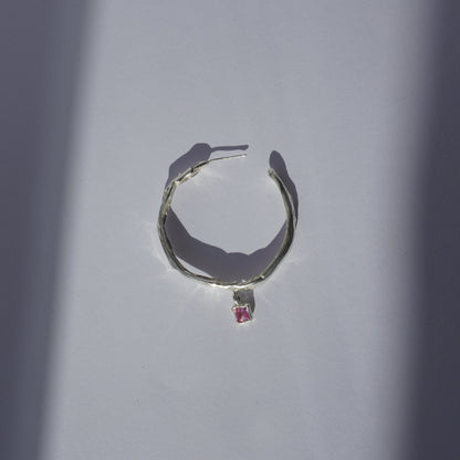 Handcrafted silver hoop earring with irregular organic shape and pink hand-set gemstone