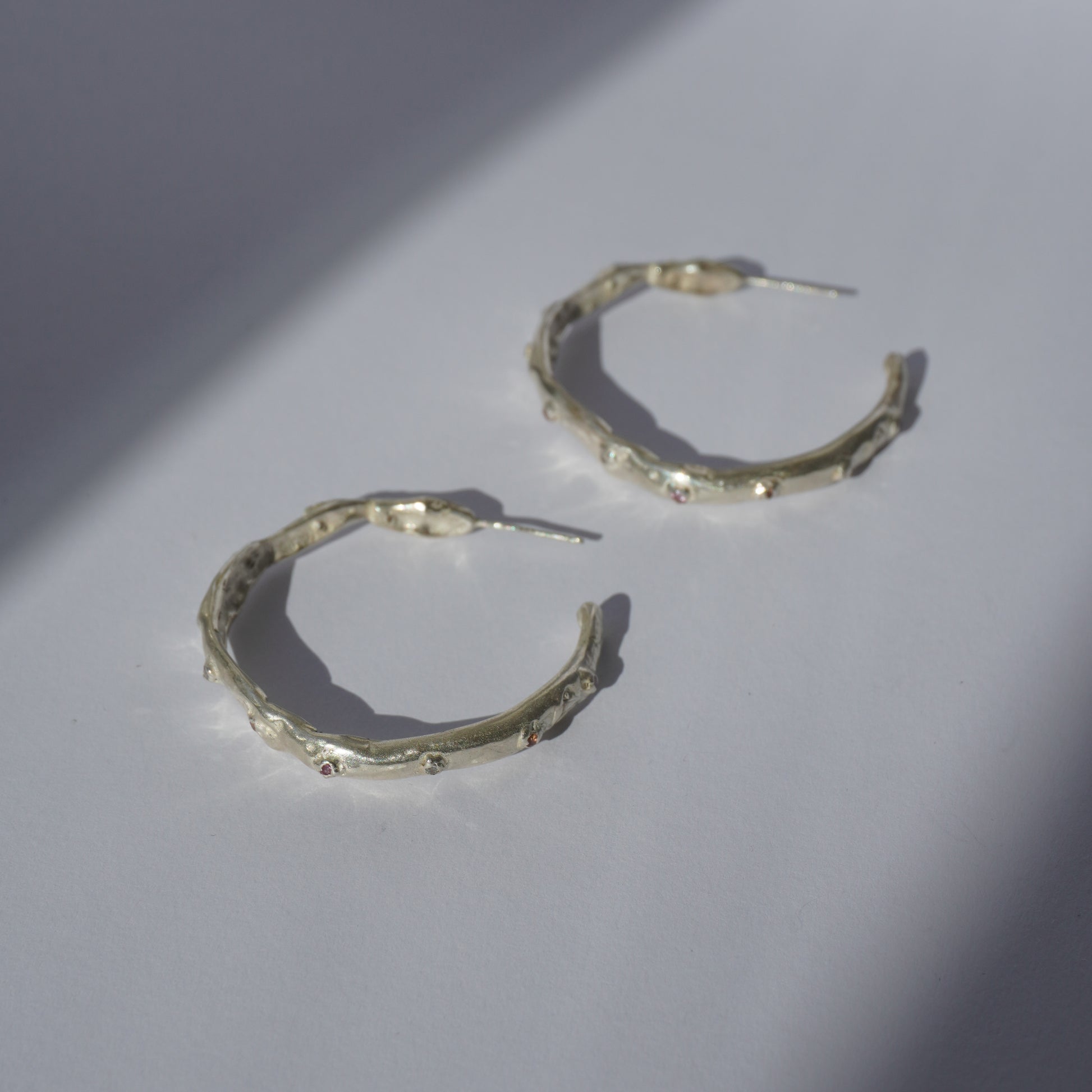 Silver handcrafted hoop earrings with organic irregular sculptural shape