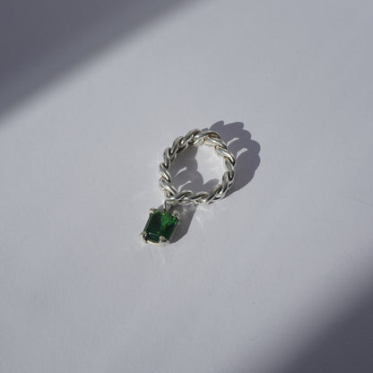 Handcrafted silver ring with twisted band and hanging emerald-cut green gemstone