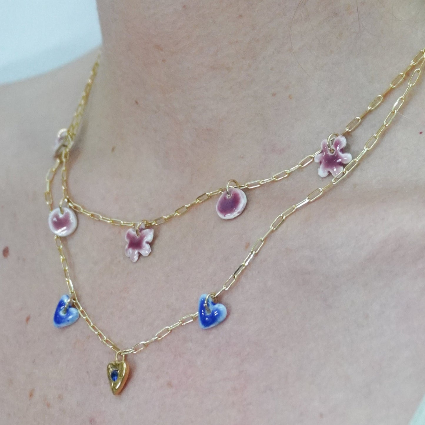 Gold plated chain with handmade lilla and blue porcelain pendants.
