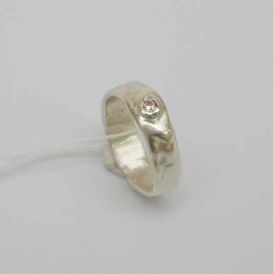 Handcrafted sterling silver ring inspired by the organic movement of nature's currents. Featuring a distinctive wave-like design and a champagne synthetic zirconia